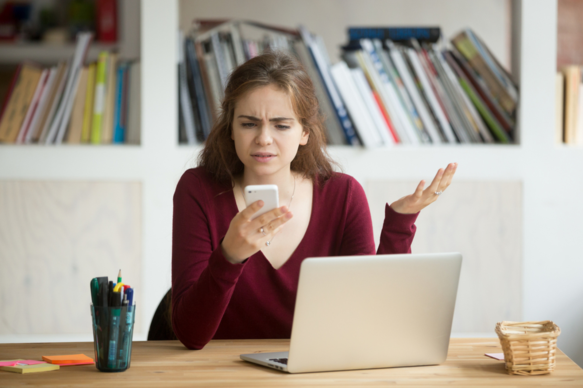 Woman looking frustrated while using her phone.